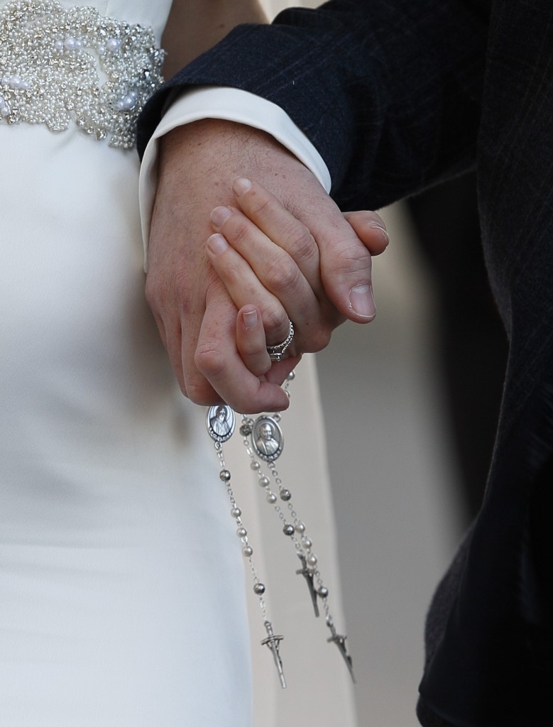 A newly married couple hold rosaries in their hands as they leave Pope Francis' general audience in St. Peter's Square at the Vatican Feb. 24. (CNS photo/Paul Haring) See POPE-AUDIENCE-POWER Feb. 24, 2016.